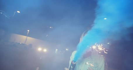 Young hipster girl friends having fun running with sparklers and smoke grenade and night with shopping cart