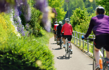 Group of Sportive man cycling in sunny park in hot summer day. Switzerland, Europe