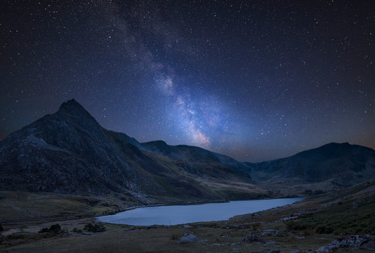 Digital composite Milky Way image of Stunning landscape image of countryside around Llyn Ogwen in Snowdonia