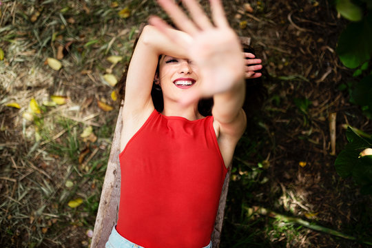 Beautiful young woman covering the sun with her hand in the fore