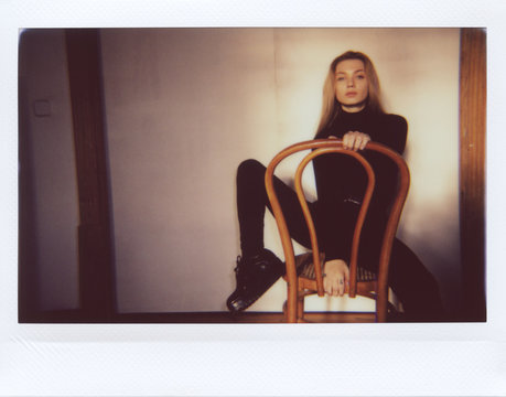 Beautiful model in black sitting on chair