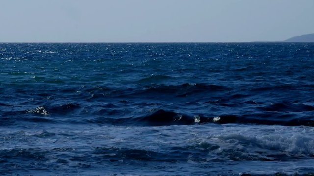 Time lapse, Sailboat on the horizon in a rough sea