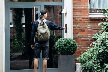 The tourist rings the doorbell to check in to the room he has booked or the student with the backpack returns home after classes at the institute or on vacation.