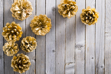 golden pine cones Christmas decoration on old rustic wooden table background