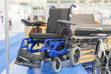 Wheelchair at a medical exhibition. Wheelchair with electric motor