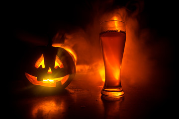 Glass of cold light beer with pumpkin on a wood background for Halloween. Glass of fresh beer and...