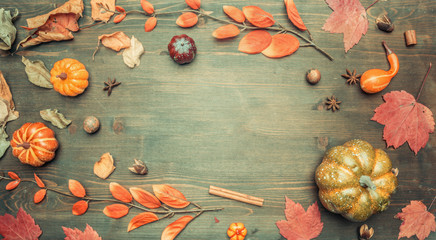 autumn composition, yellow leaves, small pumpkins frame on a wooden background, space for text flat lay