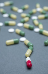 Training of random capsules white and green isolated on a blue background, conceptual image, conceptual image