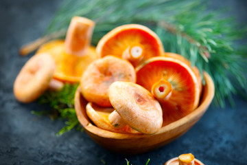 Raw wild Saffron milk cap mushrooms on dark old rustic background. Lactarius deliciosus. Rovellons, Niscalos. Organic fresh mushrooms closeup on a table