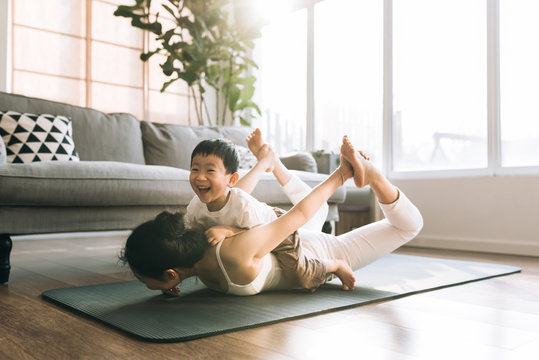 Adorable boy doing yoga with his mother