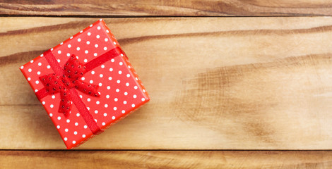 Red gift box on wooden background. Top view. Space for text.