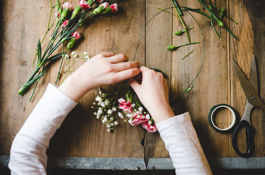 Hands of a child making a flower crown