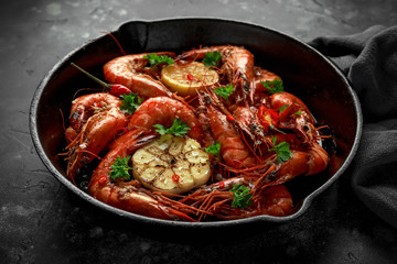 Tiger prawns fried in butter with, lemon juice, garlic and white wine served in cast iron skillet with parsley
