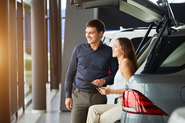 Looking for the best car. Selective focus on a car international loving couple choosing a car at the car dealership showroom copyspace family relationship purchase consumerism driving love concept