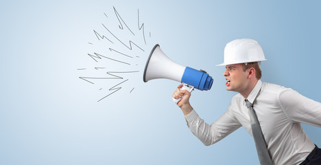 Fototapeta premium Young architect constructor yelling with megaphone and copyspace 