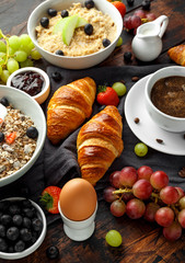 Healthy Breakfast served with coffee, orange juice, croissants, egg, cereals, oatmeal and fruits.