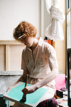 Painter priming canvas