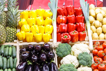 Different vegetables and fruits are in boxes on the market.