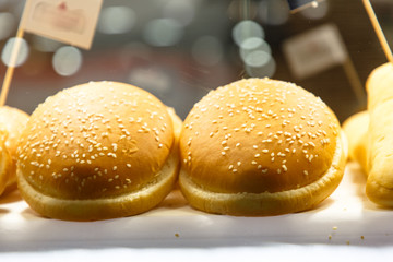 Buns with sesame for burgers are on the counter of the store.