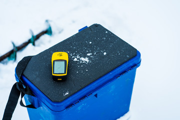 Winter fishing on ice. Winter fishinig equipment, GPSS navigator, drill and sit