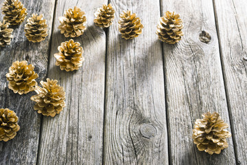 golden pine cones Christmas decoration on old wood table background
