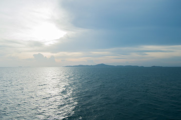 Fototapeta na wymiar Far blue seascape with mountains on horizon. Thailand Islands at the sun set. Blue sky with clouds