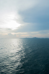  Far blue seascape with mountains on horizon. Thailand Islands at the sun set. Blue sky with clouds