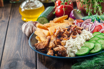 Greek gyros dish with french fries and vegetables