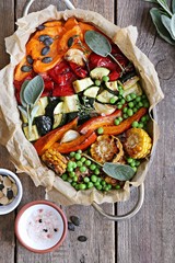 Fototapeta na wymiar Roasted vegetables in serving pan on a rustic wooden table. Overhead view.