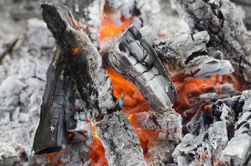 Glowing and charred wood. Red warm black coal background texture. BBQ Grill Pit With Glowing And Flaming Hot Charcoal Briquettes, Food Background Or Texture, Close-Up.