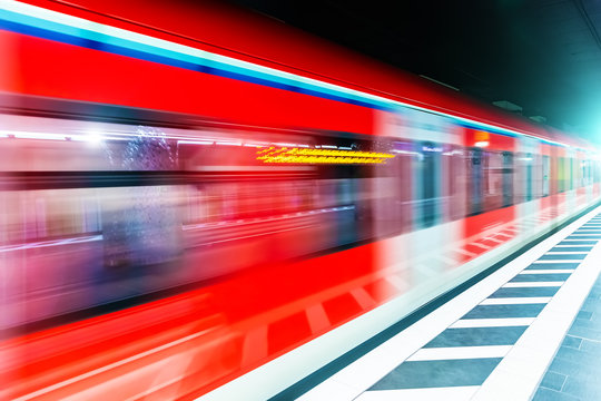 Subway metro train at railway station platform with motion blur