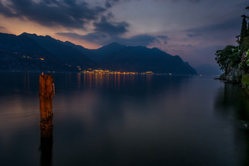 Limone and Lake Garda taken from Malcesine at dusk. The lights of Limone can be seen reflecting in the lake. Lake Garda is one of the popular lakes in the northern area of Italy in Europe.