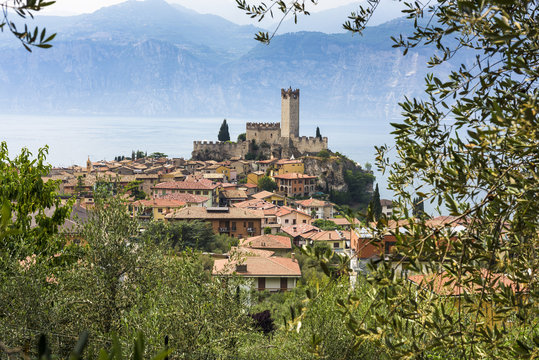 A View Of Malcesine And The 14th Century Castle Sitting On The Edge Of The Beautiful Lake Garda In Italy, Europe