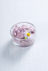 purple cosmetic cream and herbal flower on old white wood table