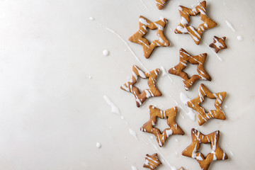 Homemade Christmas star shape sugar caramel cookies with frosting over white marble background....