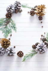 Fototapeta na wymiar Christmas decoration background: pine and cypress cones with twigs on white wood table