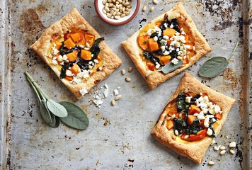 Pumpkin, chard, goat cheese and pine nuts puff pastry tarts. Overhead view