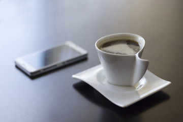 Fototapeta na wymiar White coffee cup and white smartphone on wooden table