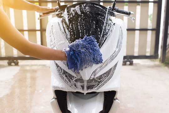 Fototapeta Car wash,Happy man cleaning motorcycle wash foam water at home