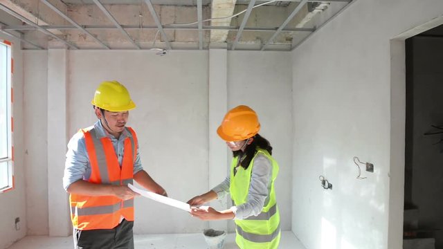 Two construction engineers working together in side building planning for the ceiling