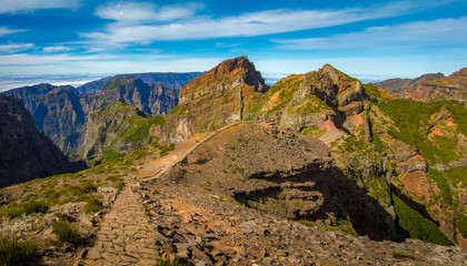 Madeira, Portugal. Tourists on a hiking path between Pico do Arieiro and Pico do Ruivo above the clouds.