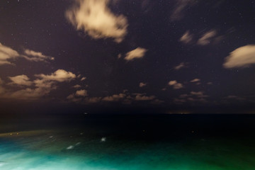 Clouds and stars over the night sea.