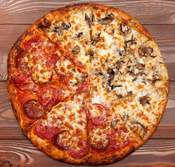 Pizza two in one, vegetarian mushroom and meat on a wooden table.