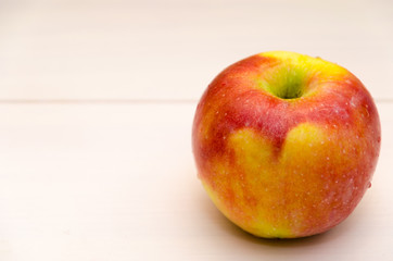 Close-up of an apple on white wooden background