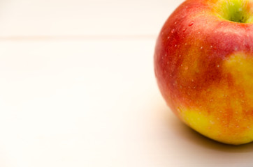 Close-up of red apple on white wooden background
