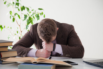 the man is tired and asleep at a table in a business Office