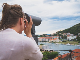 Woman using coin operated panoramic telescope.