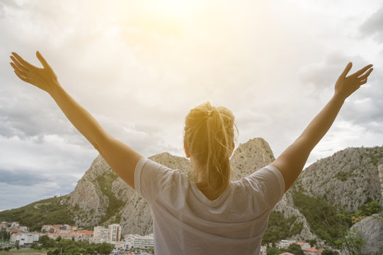 Woman with arms wide open enjoying views.