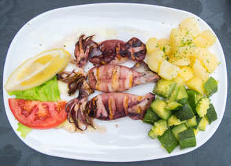 Fried squids with vegetables in a restaurant.