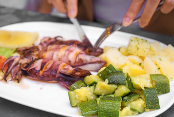 Fried squids with vegetables in a restaurant.